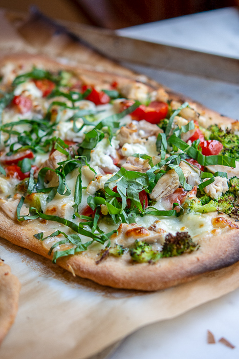Chicken and broccoli pizza on parchment paper