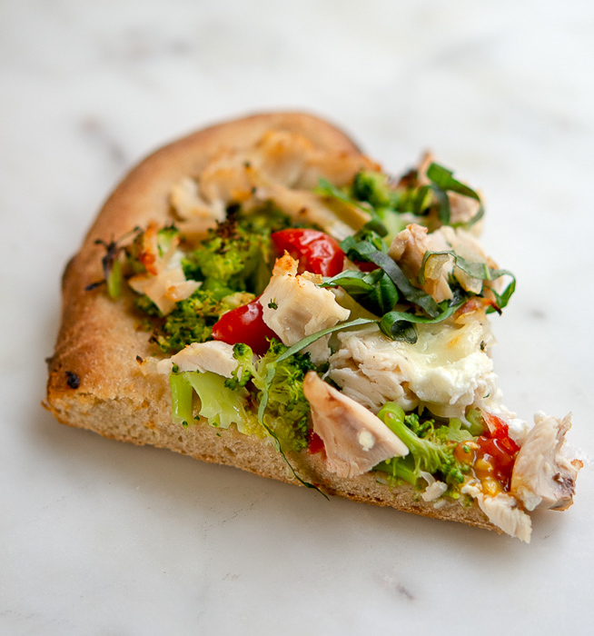 Slice of chicken and broccoli pizza