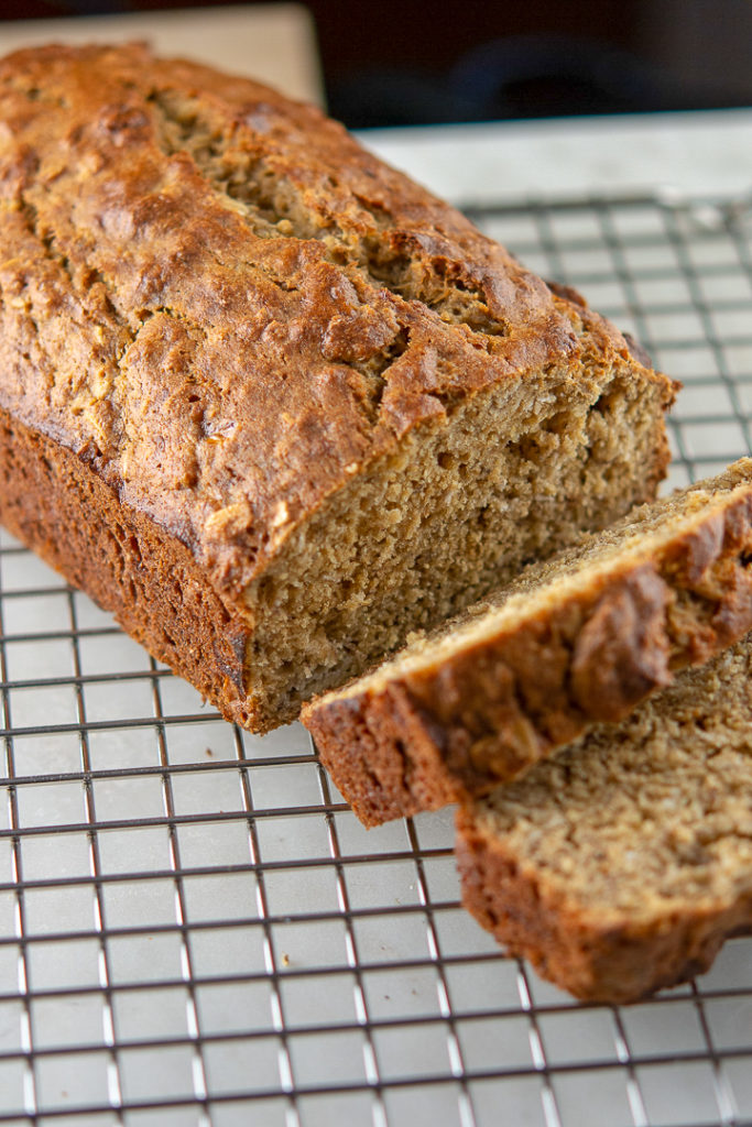 banana oat bread loaf sliced on a wire rack