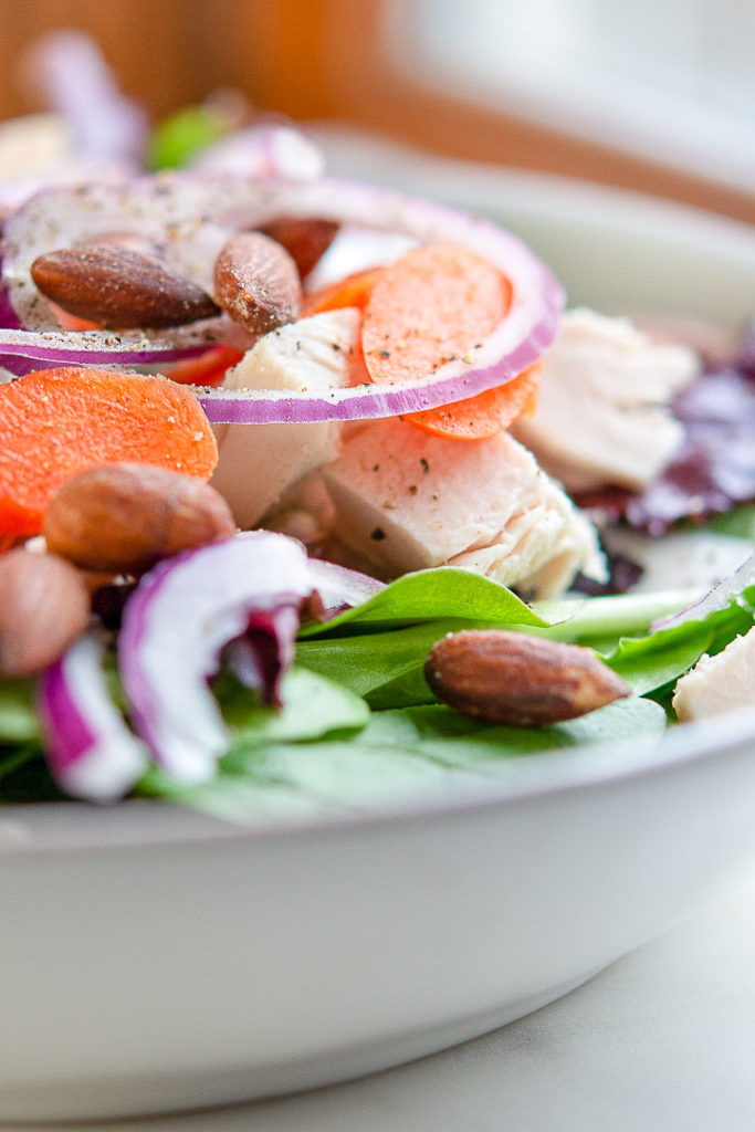 green salad with carrots, almonds and red onion and homemade ranch dressing
