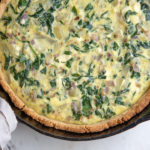 Overhead photo of spinach and artichoke quiche in cast iron pan