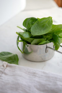 raw spinach in a measuring cup
