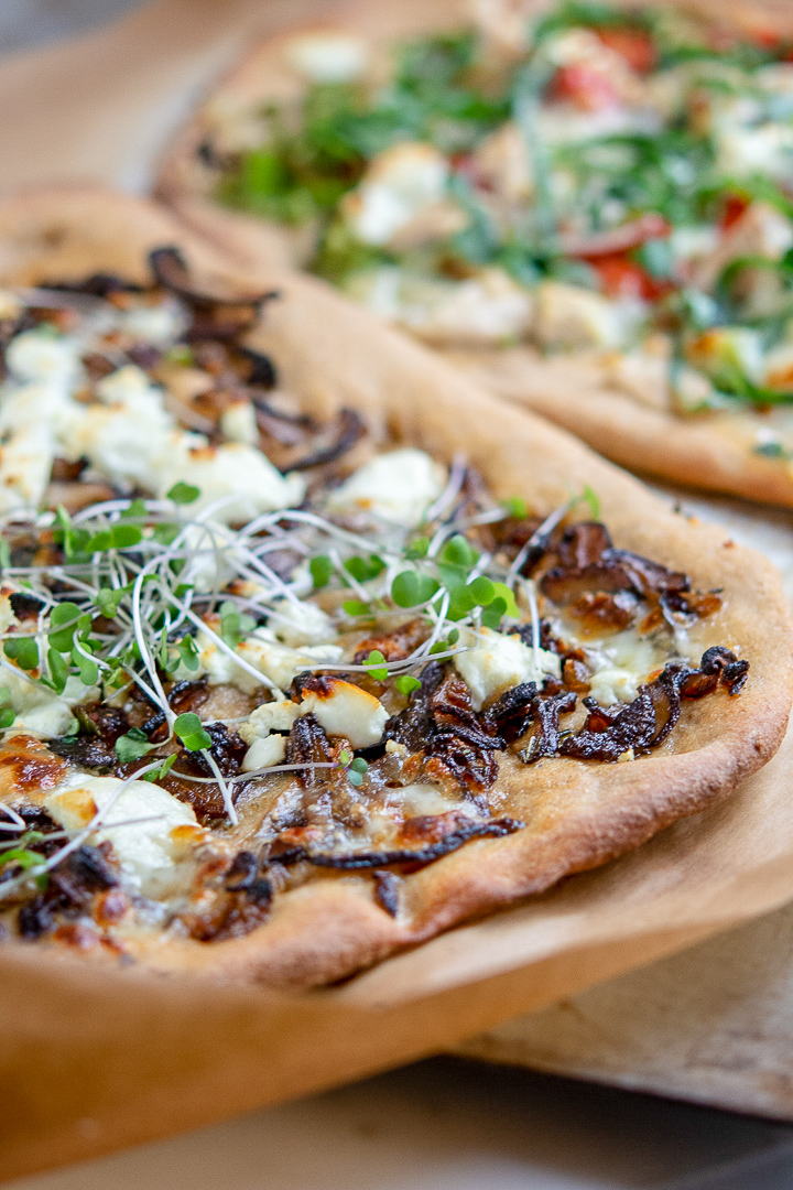 White whole wheat pizza crust with mushrooms, cheese and micro greens
