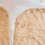 white whole wheat pizza dough on parchment paper