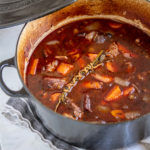 Guinness Beef Stew with mashed potatoes in a black le creuset pot