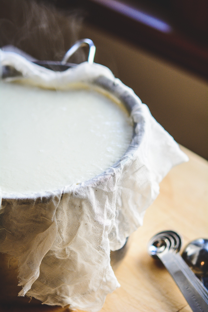 Ricotta cheese in strainer with cheesecloth photo and measuring spoons