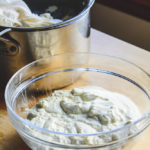 Finished fresh ricotta cheese in a glass bowl