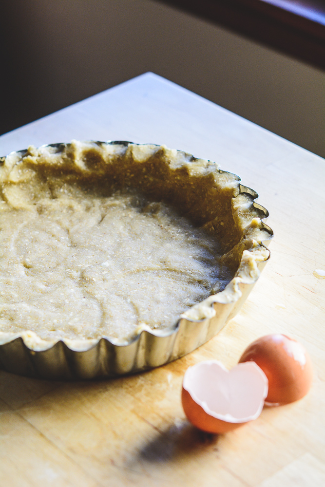 almond and oat flour dough in the tart pan, ready for the oven