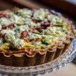 Baked asparagus and ricotta quiche on a pretty glass cake stand