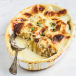 Baked Potatoes Dauphinoise in baking dish with nice spoon