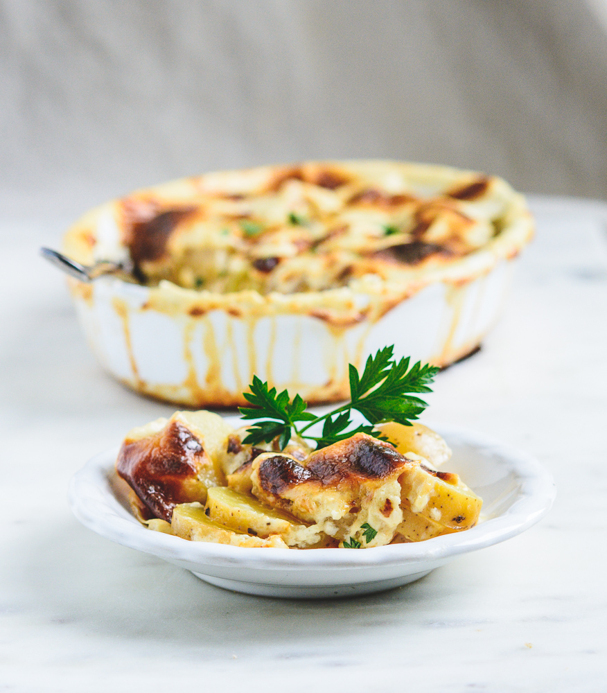 side shot of Potatoes Dauphinoise in baking pan and plate