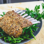 photo of rack of roasted lamb, on a bed of parsley