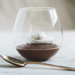 Chocolate Mexican Pots de Creme with whipped cream in a stemless wineglass and spoon
