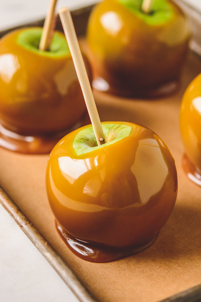 close up of caramel apple on a rimmed sheet pan