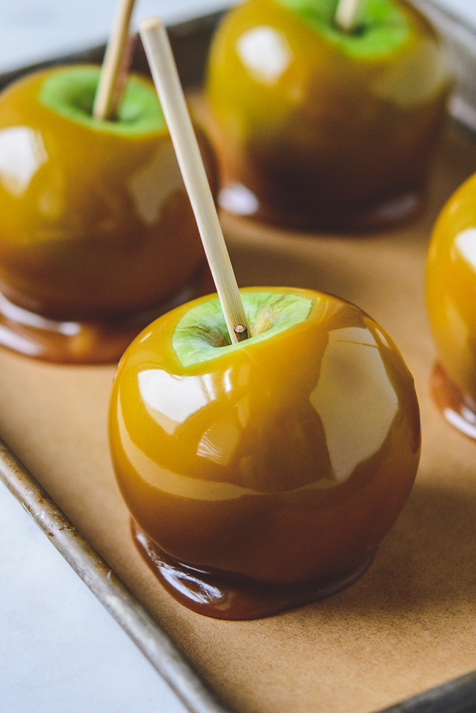 Close up of caramel apple on a rimmed sheet pan