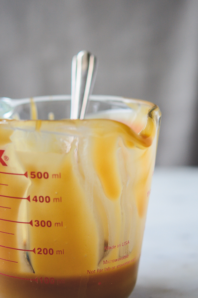 Measuring cup and spoon with caramel for apples