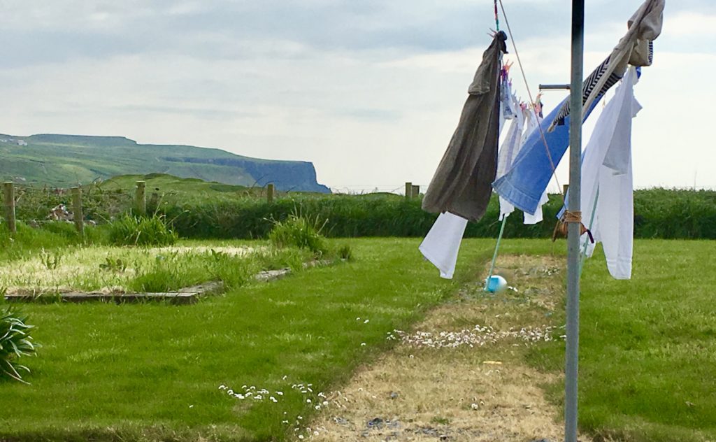 photo of laundry on the line with cliffs of moher in the background
