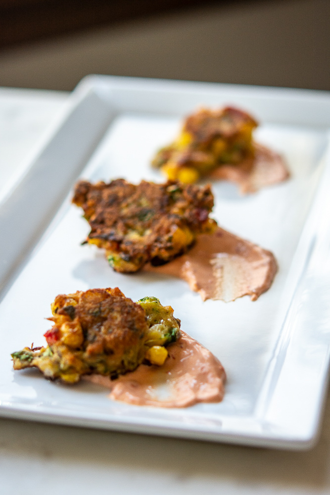 photo of corn zucchini fritters on a white plate