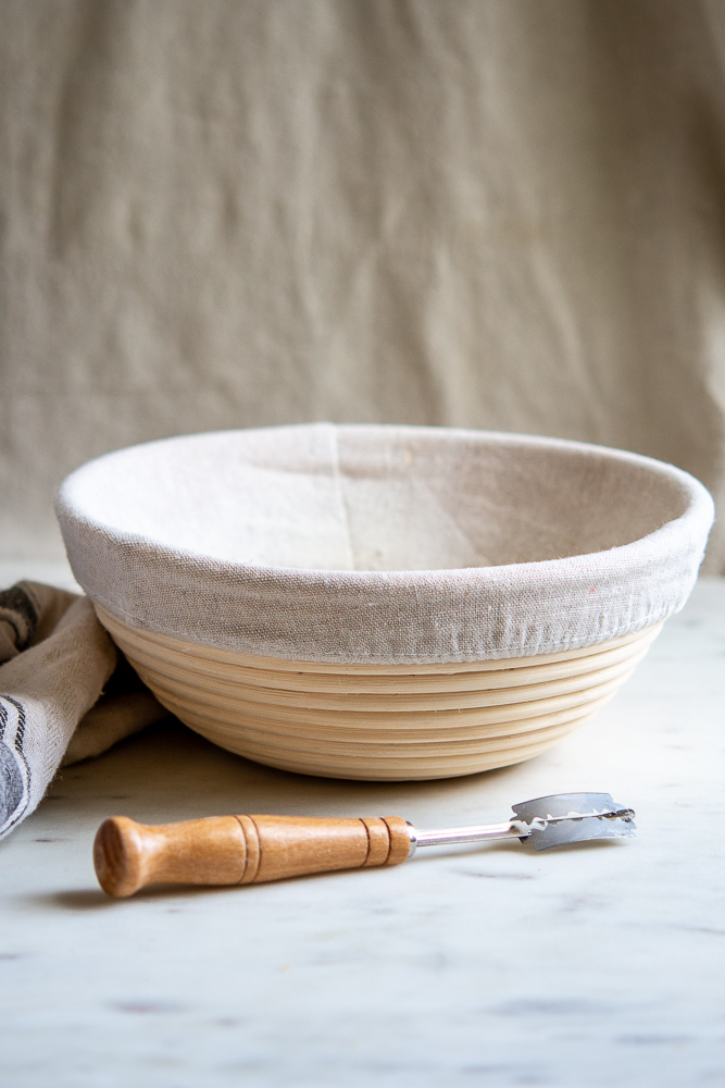 photo of banneton and lame (wicker bowl with linen liner and razorblades on a handle)