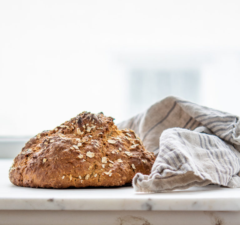 Loaf of irish soda bread next to a kitchen towel