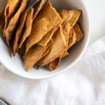 Rustic sourdough crackers lined up in a bowl