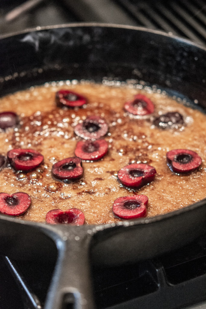 Pineapple Upside-Down Cake cast iron pan with cherries in sugar and butter