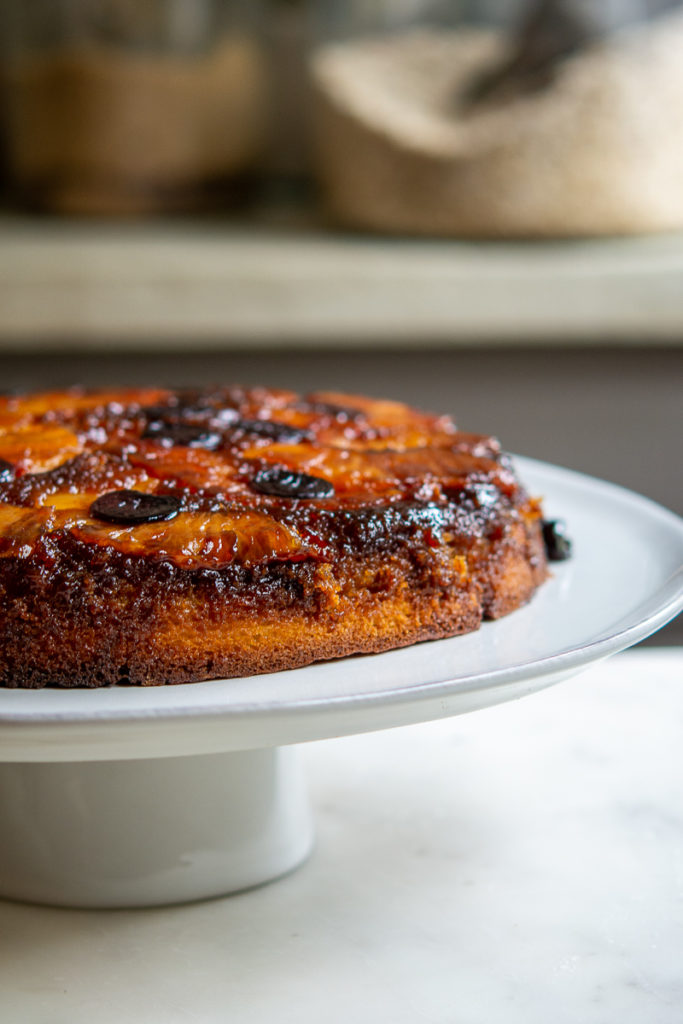 Kitchen shot of Pineapple Upside-Down Cake on cake plate