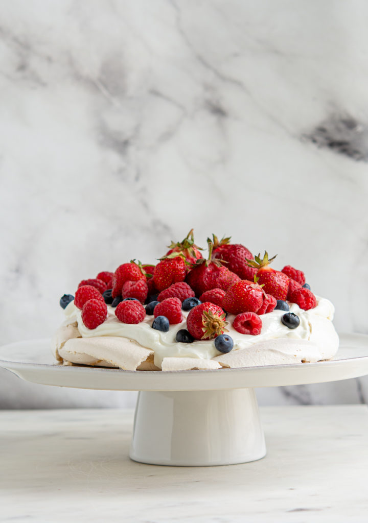 berry pavlova on a cake plate