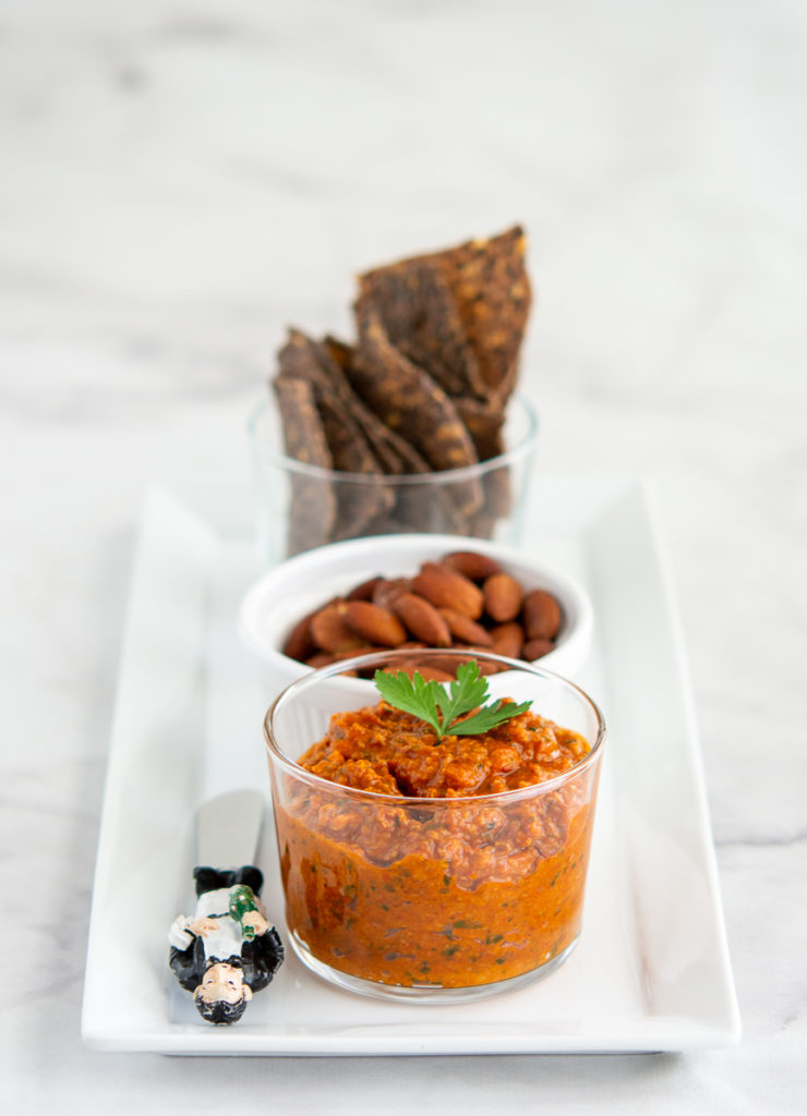 Roasted Romesco Sauce on a tray with almonds and chips