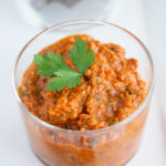 close up shot of Roasted Romesco Sauce with a piece of parsley