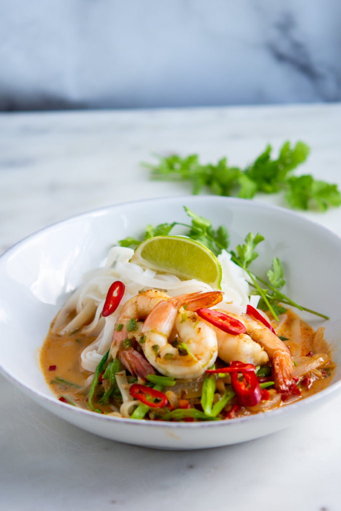 photo of Spicy Shrimp Rice Noodles and Coconut Curry in a bowl with a lime wedge