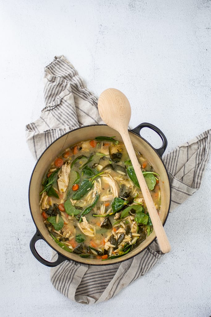 Overhead shot of chicken soup with lemon and orzo in soup pot