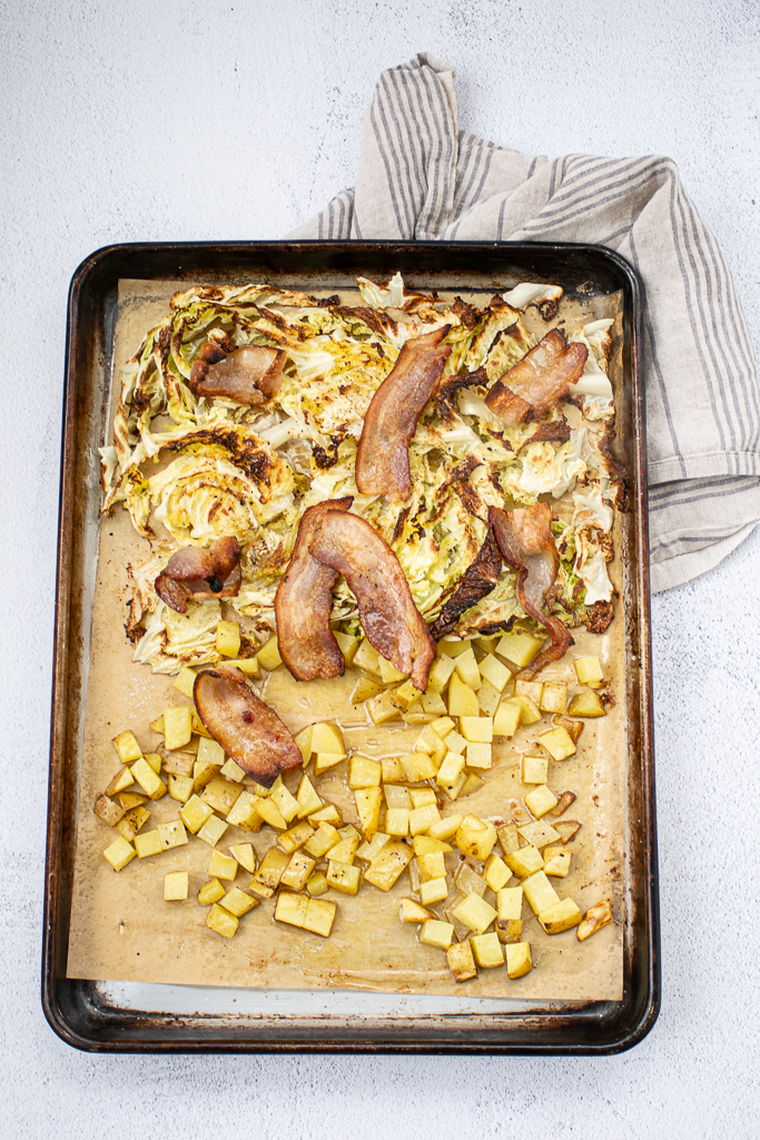 overhead shot of cabbage, potatoes and bacon in a sheet pan with towel underneath for Shelagh's Irish Pizza