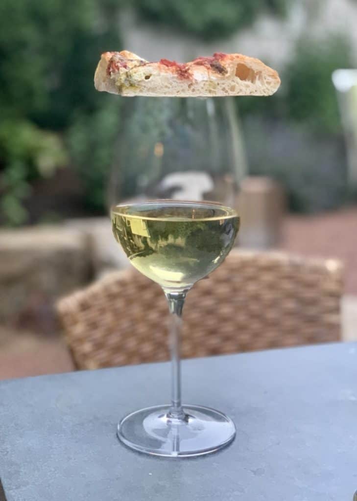 Slice of pizza on a wine glass