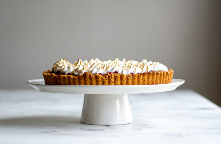 sideview of cranberry tart on cake pedestal