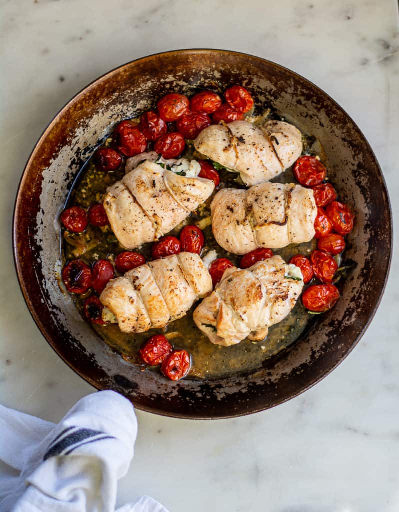overhead shot of cooked Goat Cheese Stuffed Chicken with Oven Roasted Tomatoes in pan