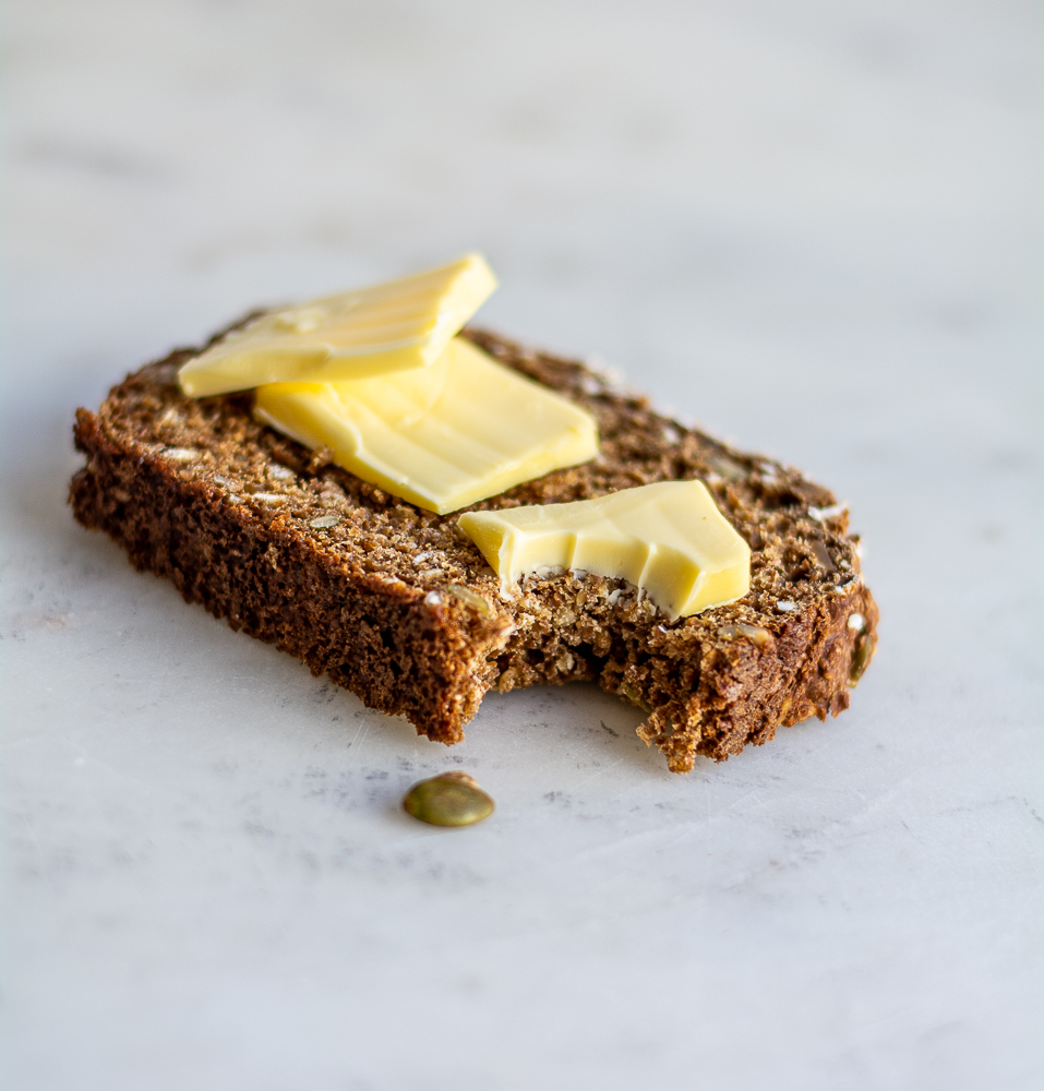 Seedy Irish Brown Bread slice with butter and bite out of it