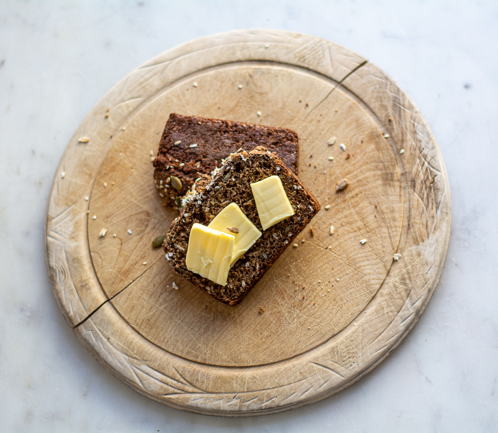 Seedy Irish Brown Bread on an old bread board with butter