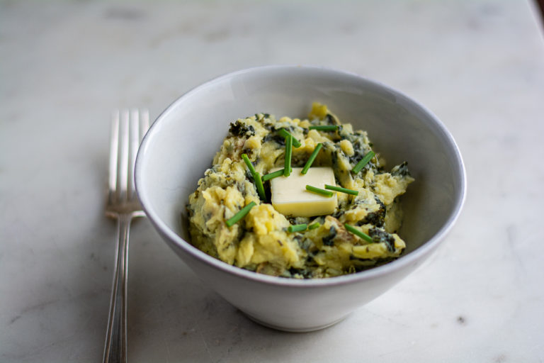 close up of colcannon in a bowl with a fork