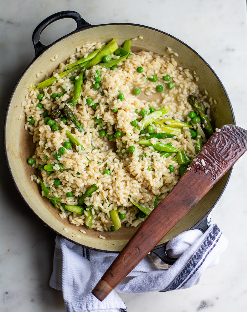 shot of spring risotto in pan with wooden spoon