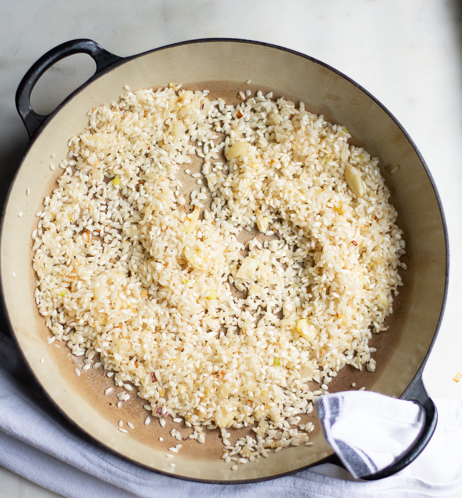 overhead shot of sauteed shallots and arborio rice