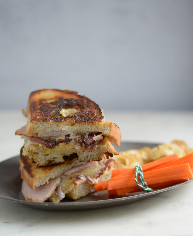 cheese toastie sandwich, stacked on a plate, served with carrots and chips