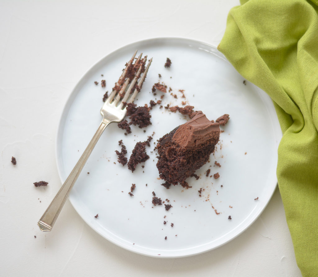 Overhead shot of eaten Guinness Chocolate Cake with Irish Whiskey Frosting with fork and green napkin