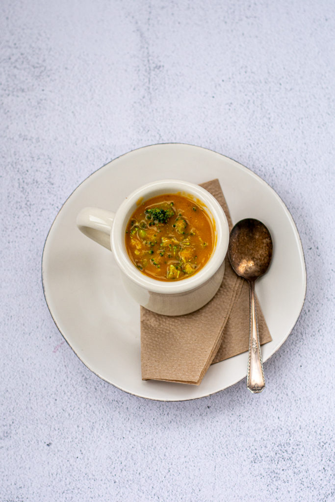 Photo of a cup of Irish vegetable soup with spoon and napkin