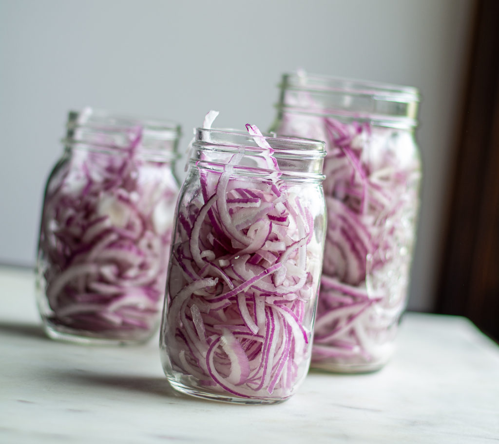 raw red onions in mason jars
