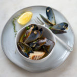 garlicky guinness mussels in a bowl with lemon