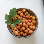 Roasted Chickpeas in a dish with a piece of fresh parsley