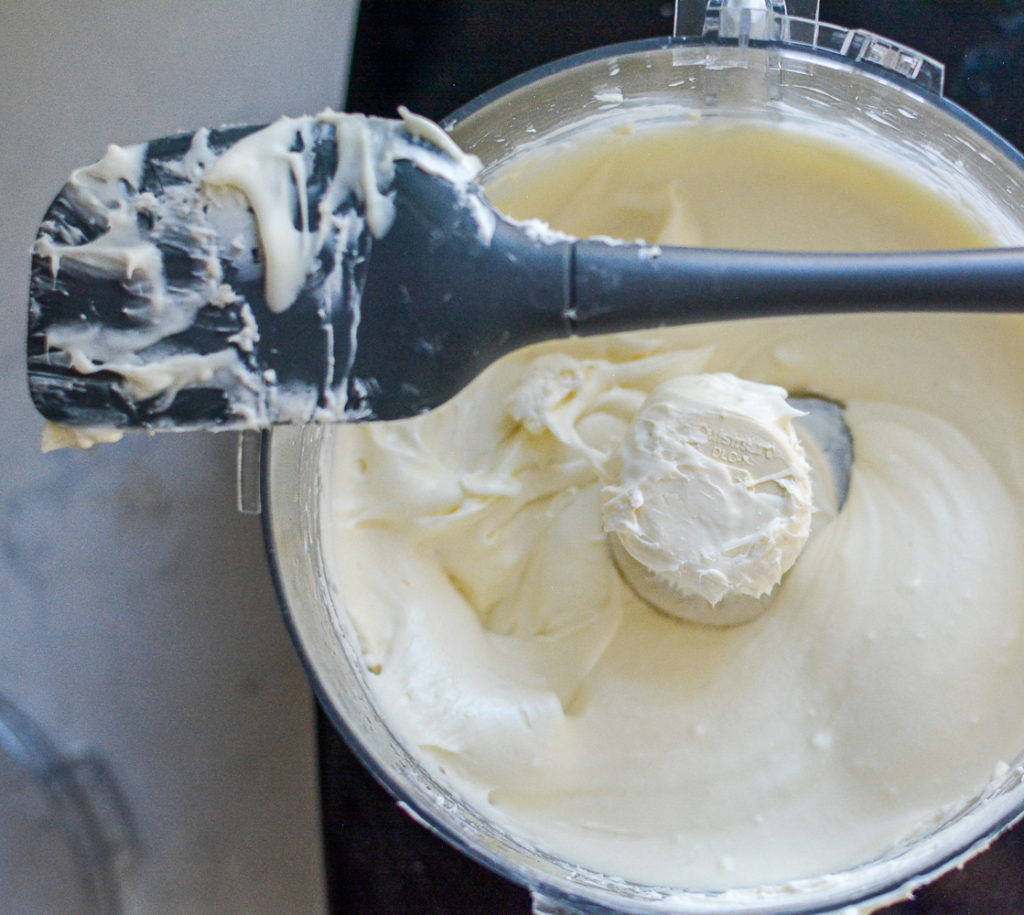 White Chocolate Cream Cheese Frosting in a food processor with a rubber spatual