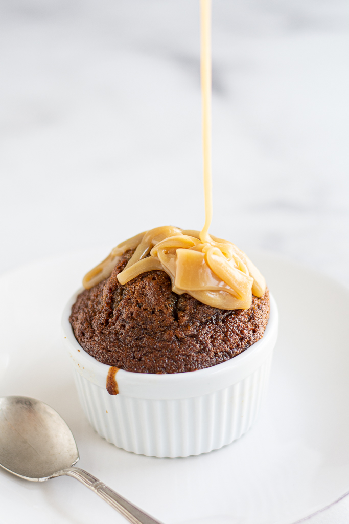 sticky toffee pudding with sauce being poured over the top