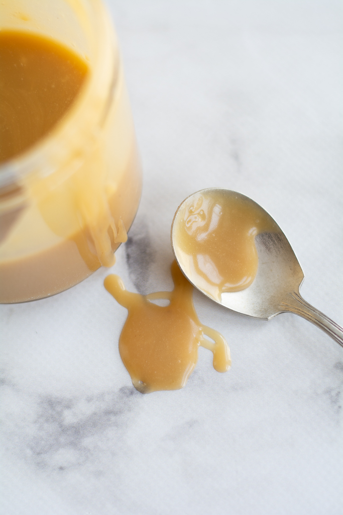 sticky toffe pudding caramel sauce in a jar and on a spoon